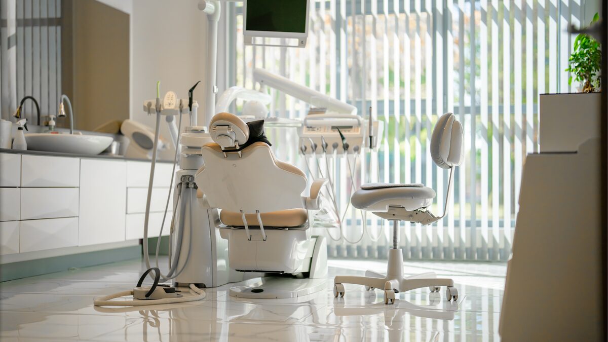 Salle de soins dentaires vide, sol lisse, après passage d’entretien.