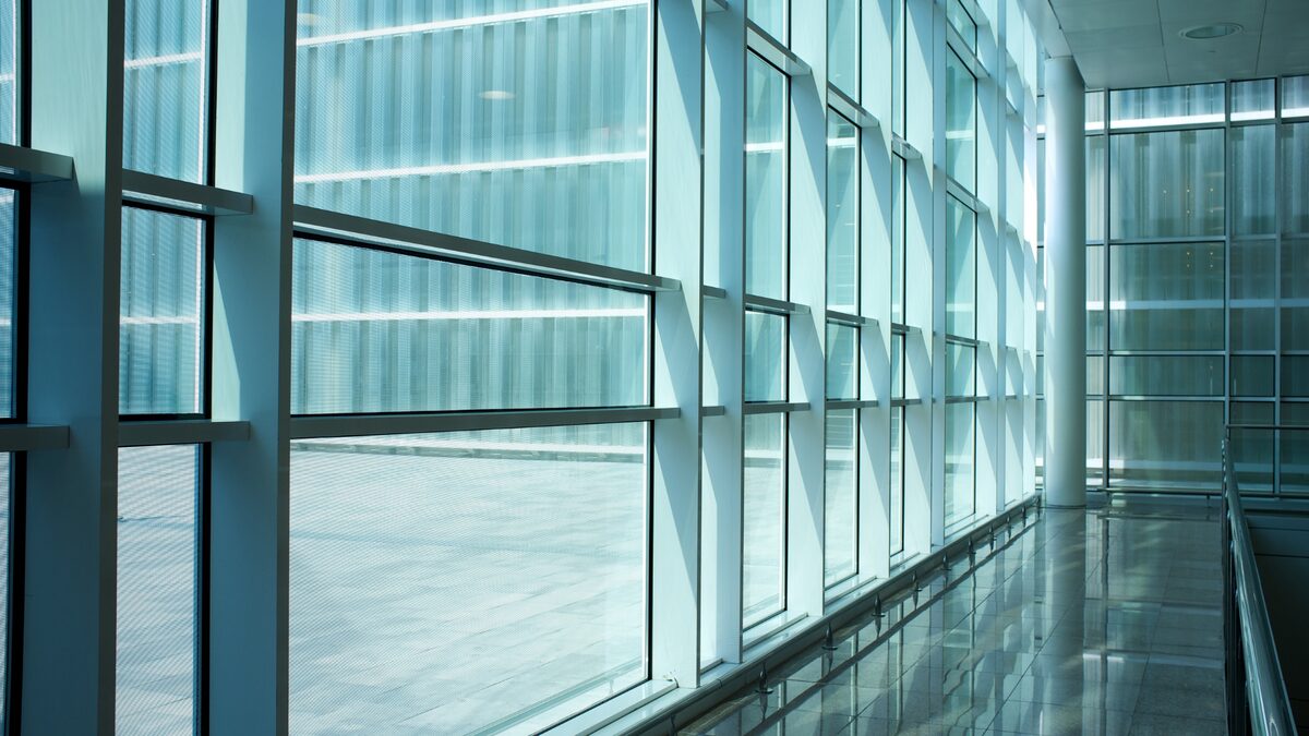 Grande façade vitrée de bâtiment professionnel, vue depuis la circulation intérieure.